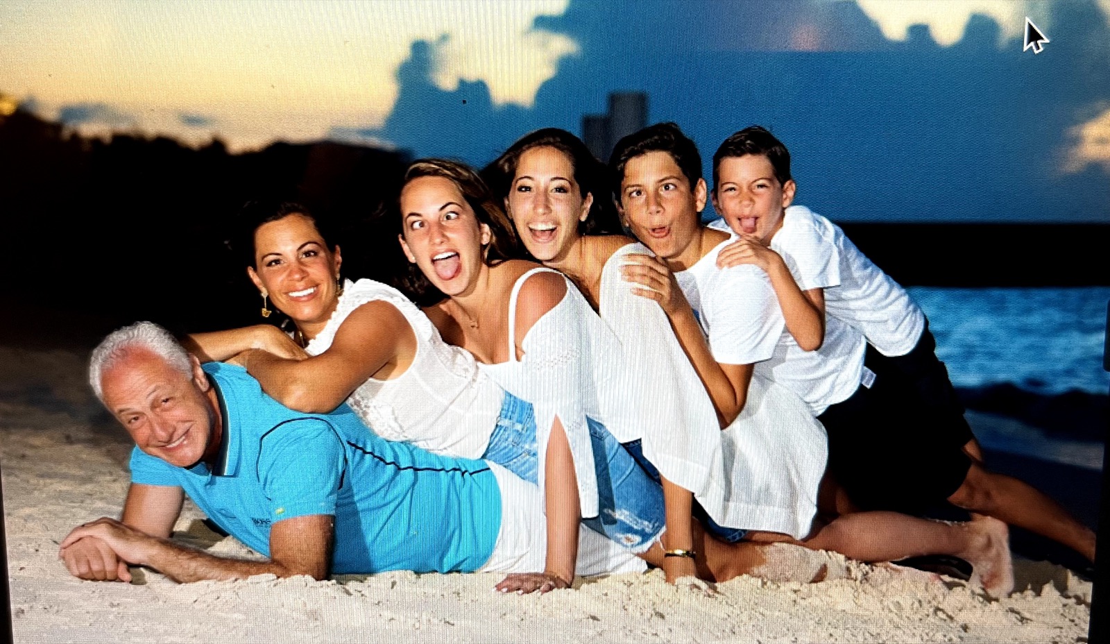 The whole family being silly on the beach at sunset